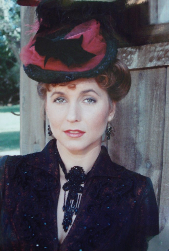 A Woman in a Black Ball Gown and a Black Hat